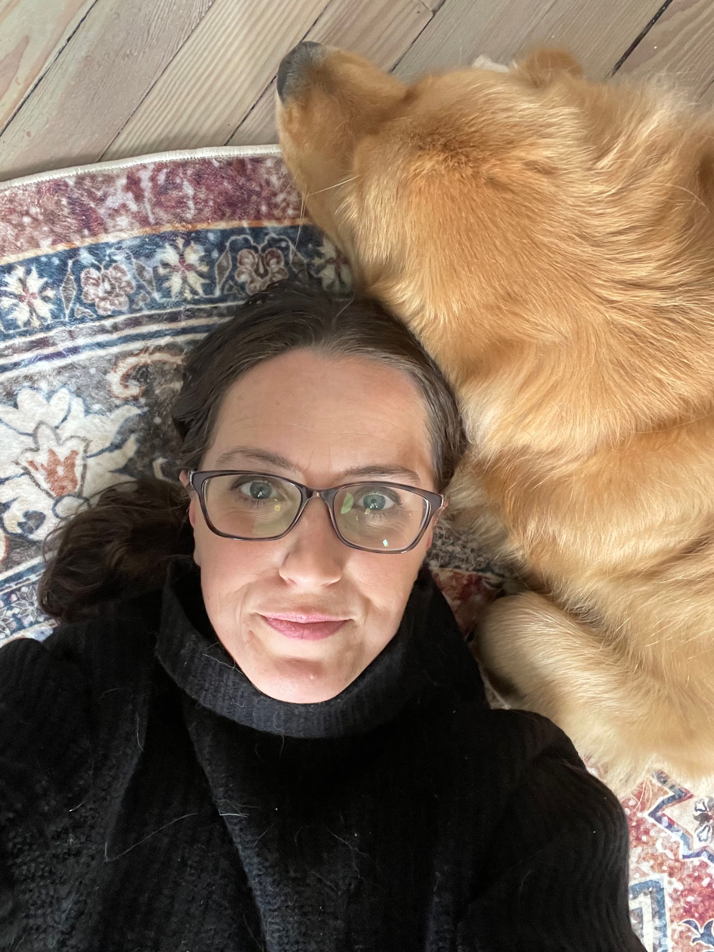 Nicole Beaudin recharging on the floor with Kai, her golden retriever